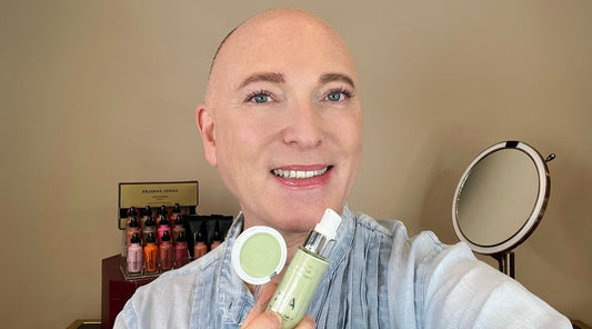 Daniel Sandler Holding A Bottle Of Anti-Redness Foundation Primer and Anti-Redness Concealer